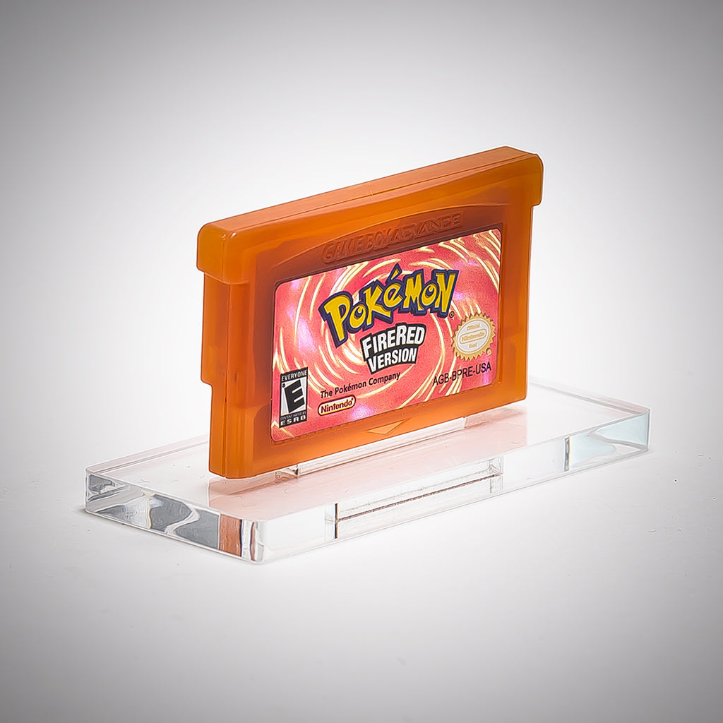 Pokémon FireRed Version game cartridge on a clear stand with a gray background