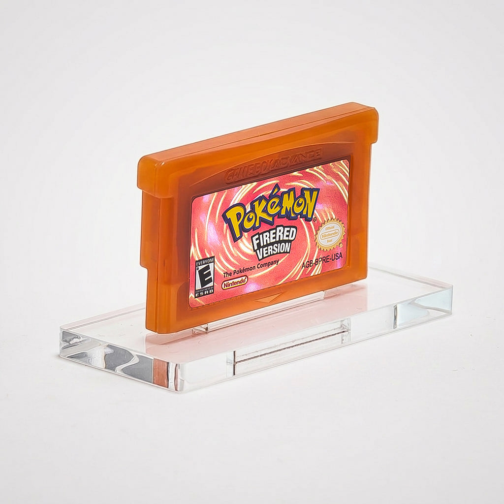 Pokémon FireRed Version game cartridge on a clear stand with a gray background